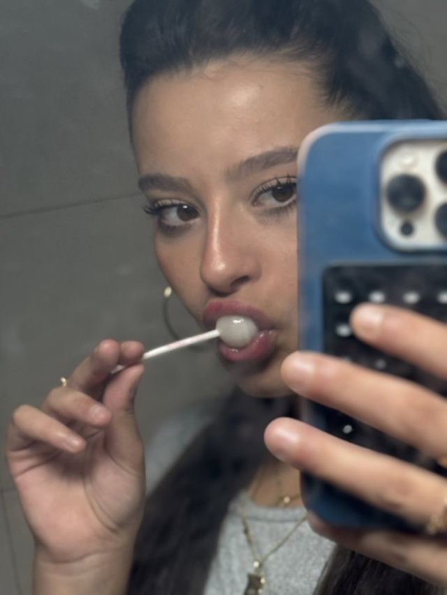 Martina taking a mirror selfie with a lollipop
